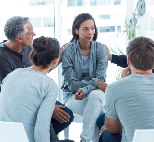 Woman getting comforted by a group of people